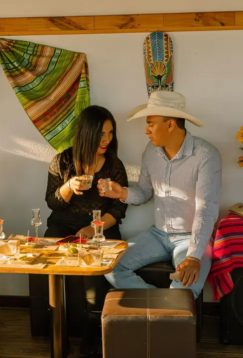 Pareja brindando con mezcal durante la cata