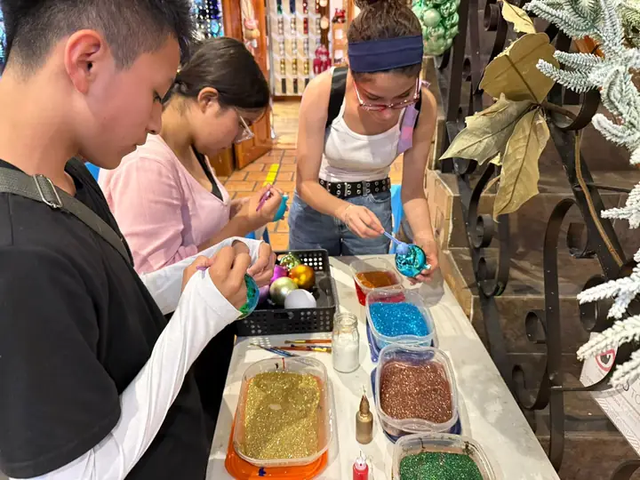Participantes decorando esferas de vidrio en el taller