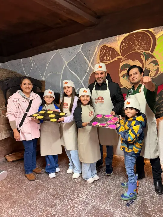 Familia con sus charolas de pan terminadas