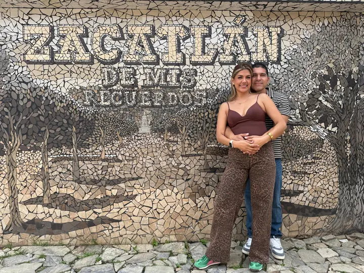 Pareja frente al mural Zacatlán de mis recuerdos