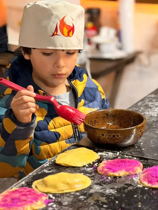 Niño decorando pan de temporada en el taller