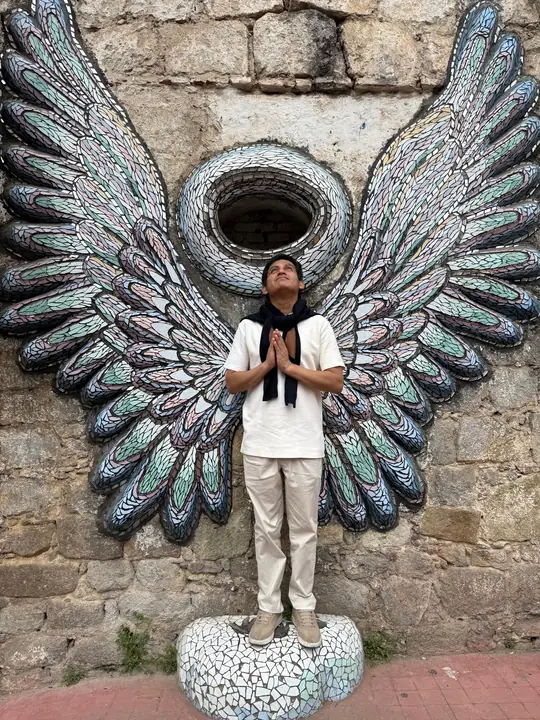 Visitante frente al vitromural de alas en Zacatlán