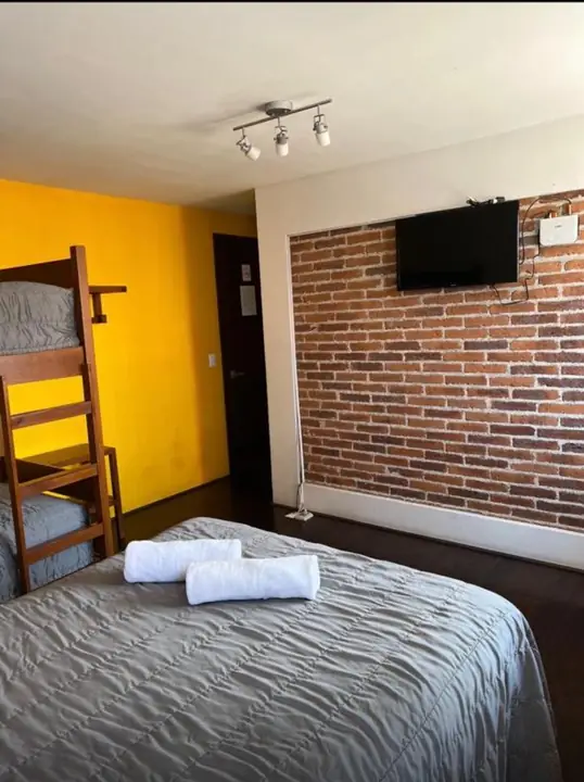 Habitación del Hotel MH con cama, litera y televisión